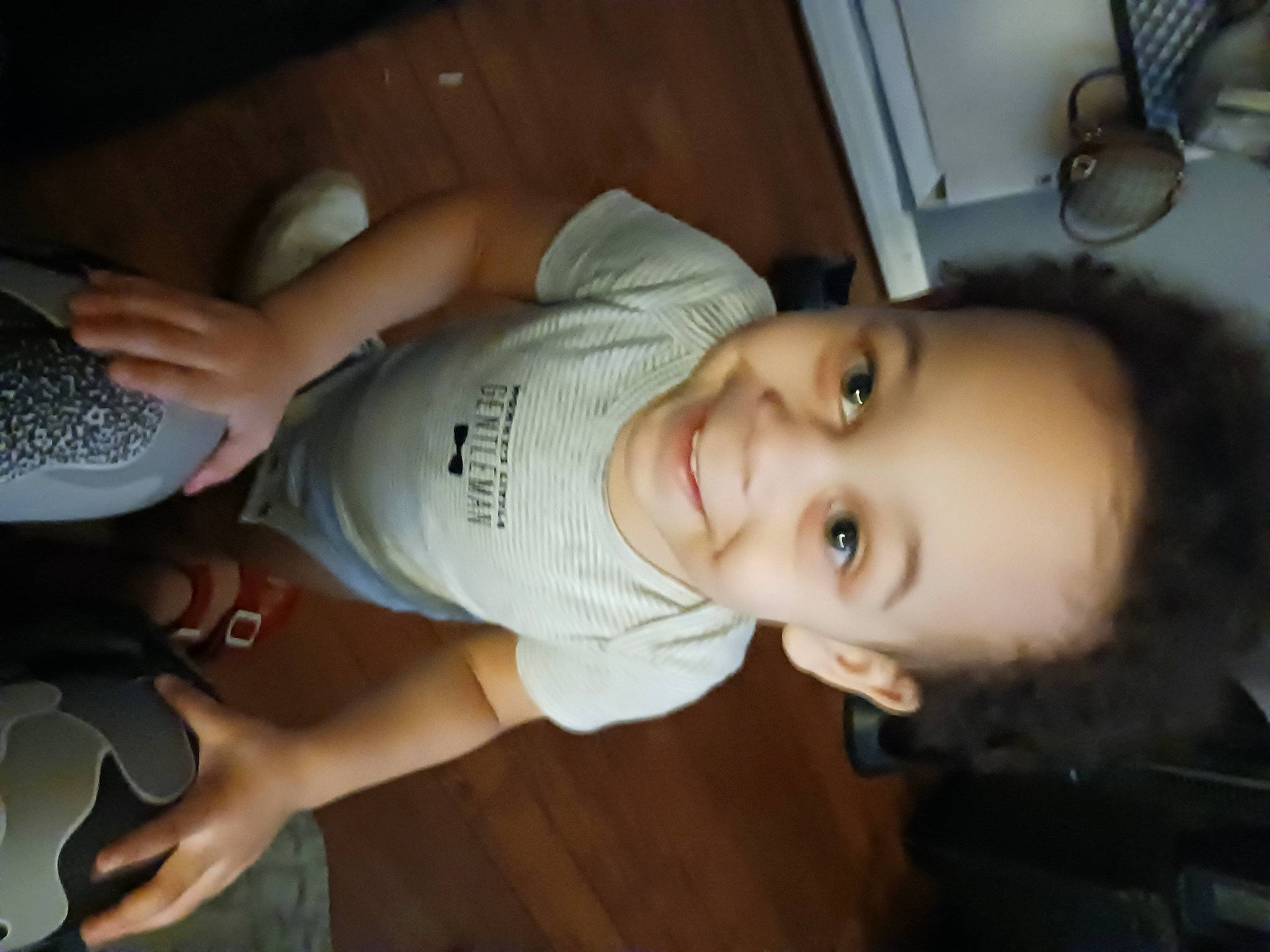 Makai is registered to the contest to win money with this photo: child, elbow, eye, flash_photography, flooring, fun, happy, hat, human_leg, input_device, joy, mouth, nose, peripheral, person, room, smile, t_shirt, thumb, toddler