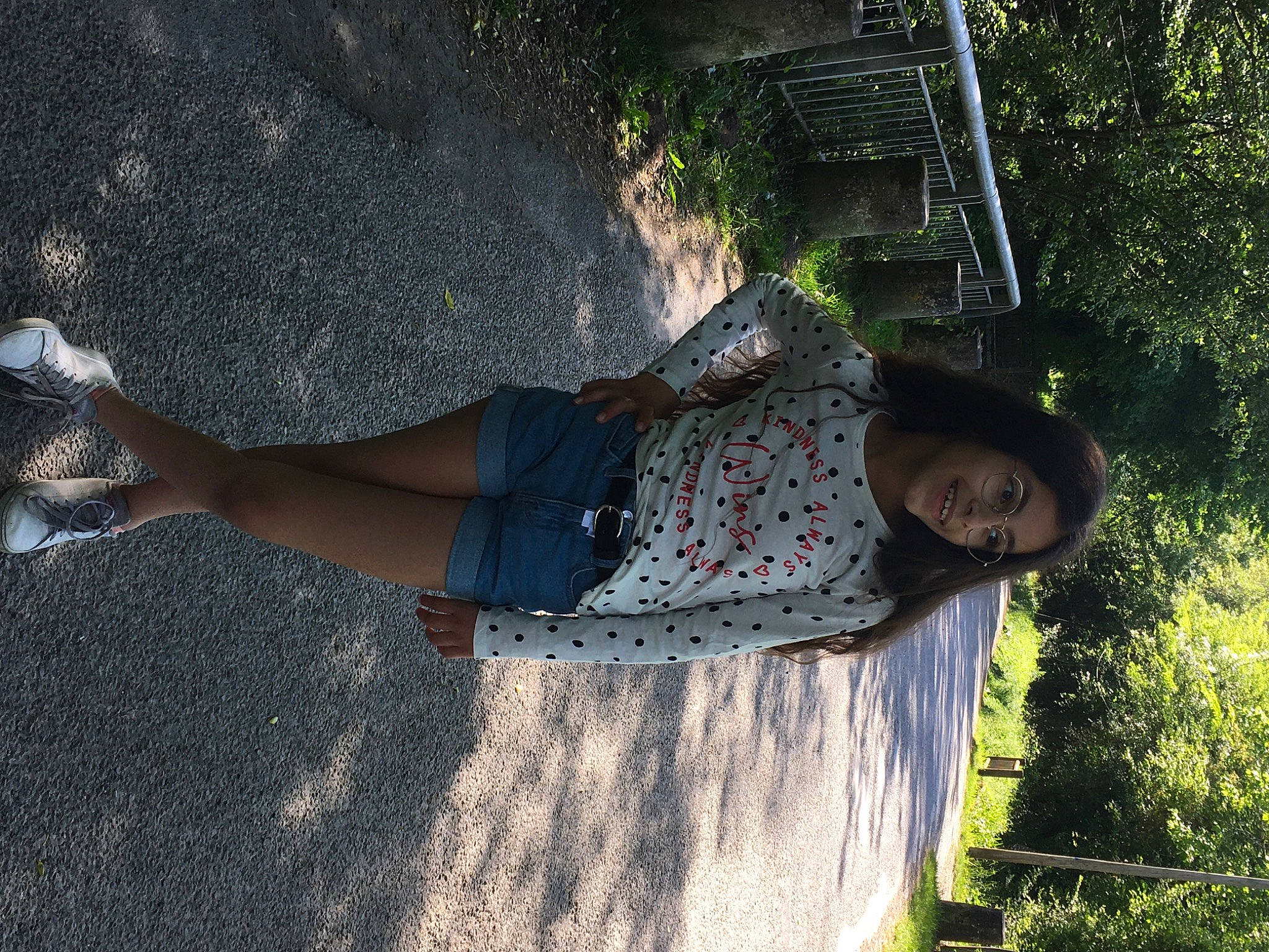 Lara participe au concours pour gagner de l'argent avec cette photo : denim, eyewear, fun, grass, hat, human_leg, joy, landscape, leisure, people_in_nature, person, plant, shadow, sitting, smile, soil, t_shirt, thigh, tints_and_shades, tree