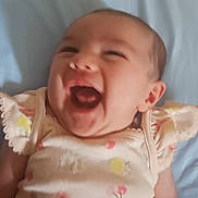 Kairi joined the competition — help win amazing prizes! baby, infant, smiling, laughing, child, cute, lying_down, clothing, floral_pattern, pink, yellow, blue_background, happy, face, head, skin, human, one_person, newborn, soft