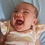 baby, infant, smiling, laughing, child, cute, lying_down, clothing, floral_pattern, pink, yellow, blue_background, happy, face, head, skin, human, one_person, newborn, soft