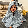 Aloïs a rejoint le concours — aidez-le/la à gagner de superbes lots ! baby, child, smiling, blue_blanket, hooded_blanket, couch, pillows, cozy, indoor, happy, face, barefoot, soft_texture, furniture, portrait, sitting, cute, infant, warm, comfort