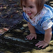 Ellie joined the competition — help win amazing prizes! toddler, child, smile, crawling, denim_overalls, outdoor, wooden_deck, sunlight, shadow, happy, playful, casual_clothing, short_hair, cute, nature, daylight, exploring, hands, face, young