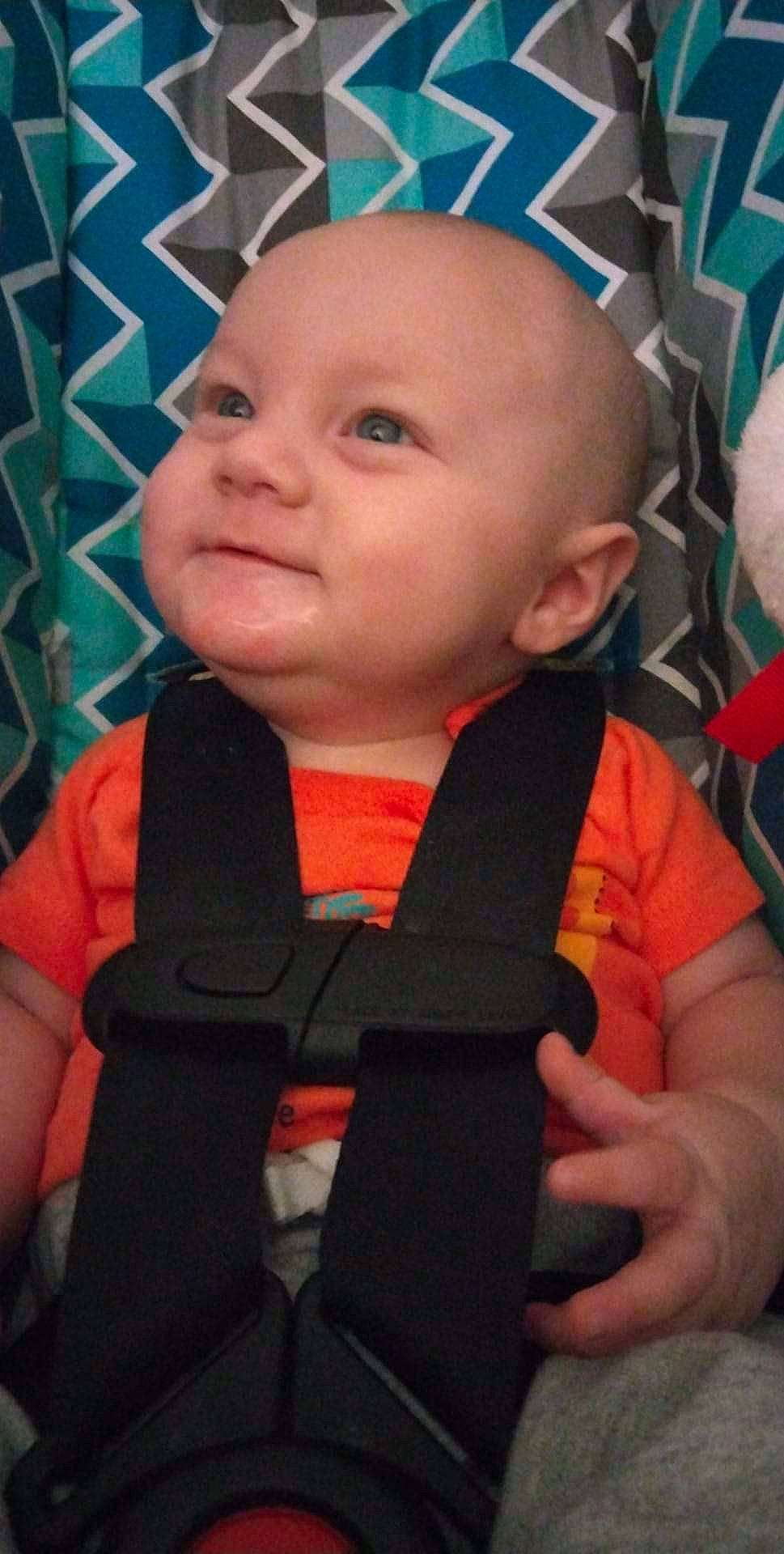 Timothy is registered to the contest to win money with this photo: arm, baby, baby_toddler_clothing, cheek, chin, eye, eyebrow, finger, forehead, fun, hairstyle, happy, head, human_body, iris, nose, person, skin, smile, thumb