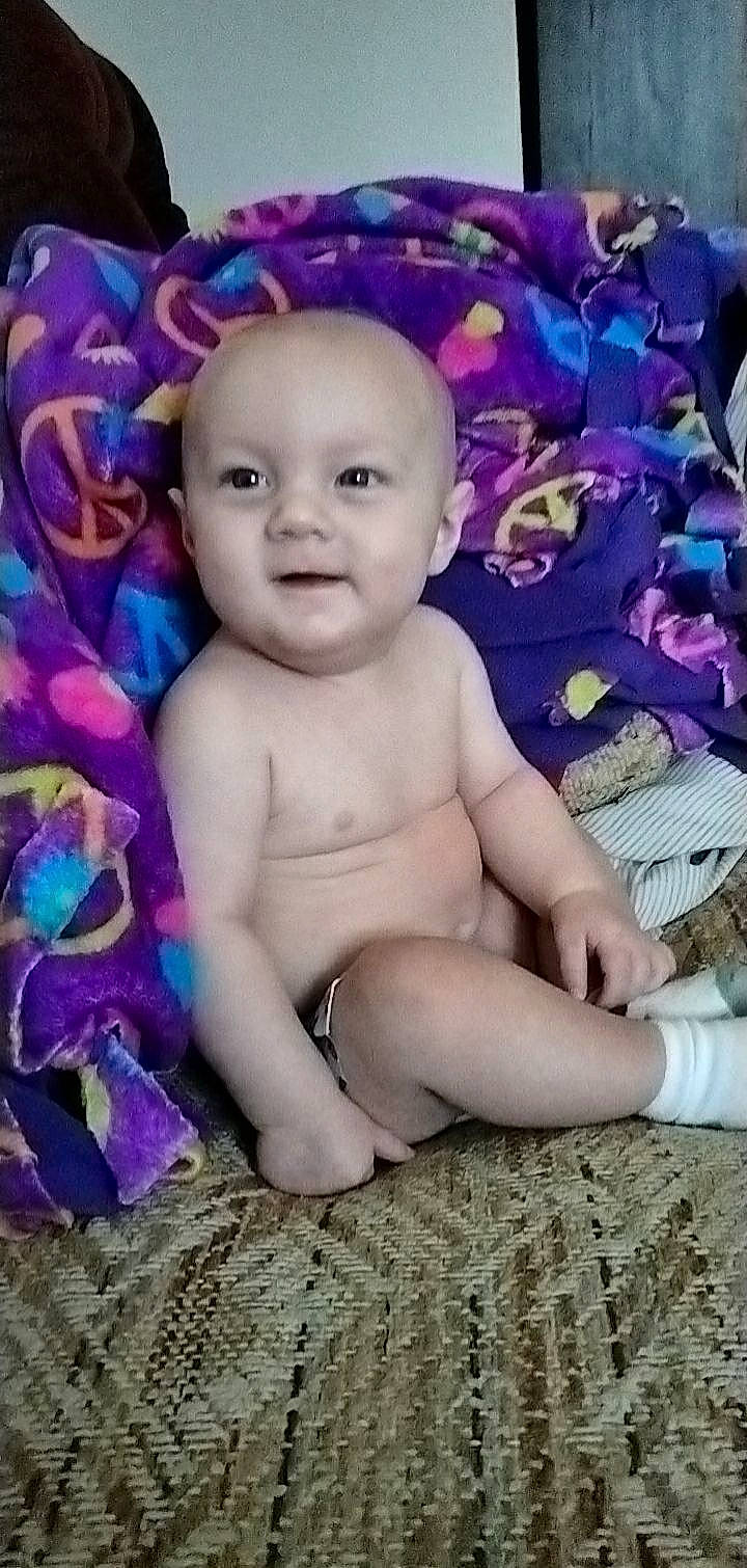 Timothy is registered to the contest to win money with this photo: baby, baby_toddler_clothing, cheek, chest, child, electric_blue, fun, happy, head, iris, lip, magenta, person, photo_caption, pink, portrait_photography, purple, sitting, smile, toddler