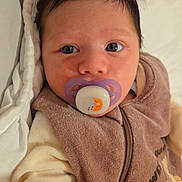 Kaïs a rejoint le concours — aidez-le/la à gagner de superbes lots ! baby, pacifier, face, infant, clothing, brown, blanket, closeup, cute, child, portrait, eyes, hand, soft, warm, indoor, young, expression, fabric, zipper