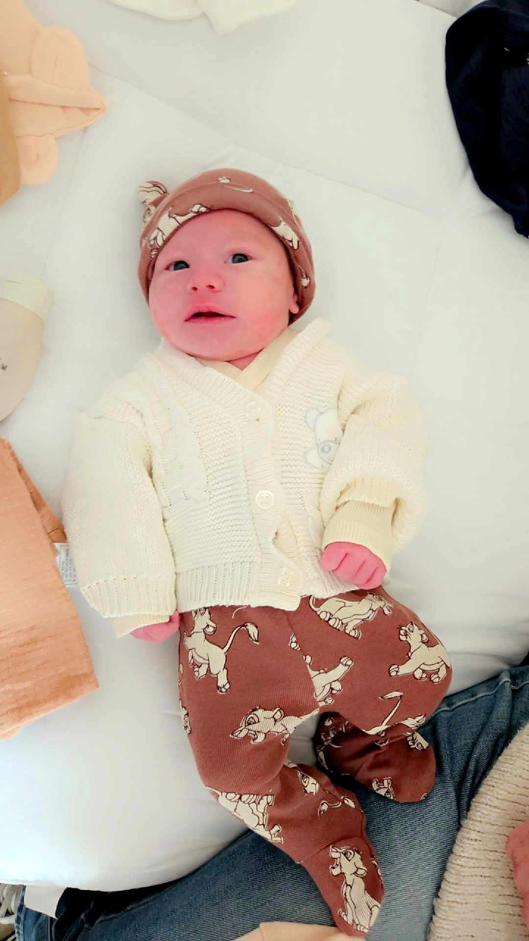 Kaïs a rejoint le concours — aidez-le/la à gagner de superbes lots ! baby, newborn, infant, clothing, hat, sweater, pants, cartoon, lion, lying_down, cushion, soft, cozy, cute, child, person, indoor, comfort, resting, sleepwear