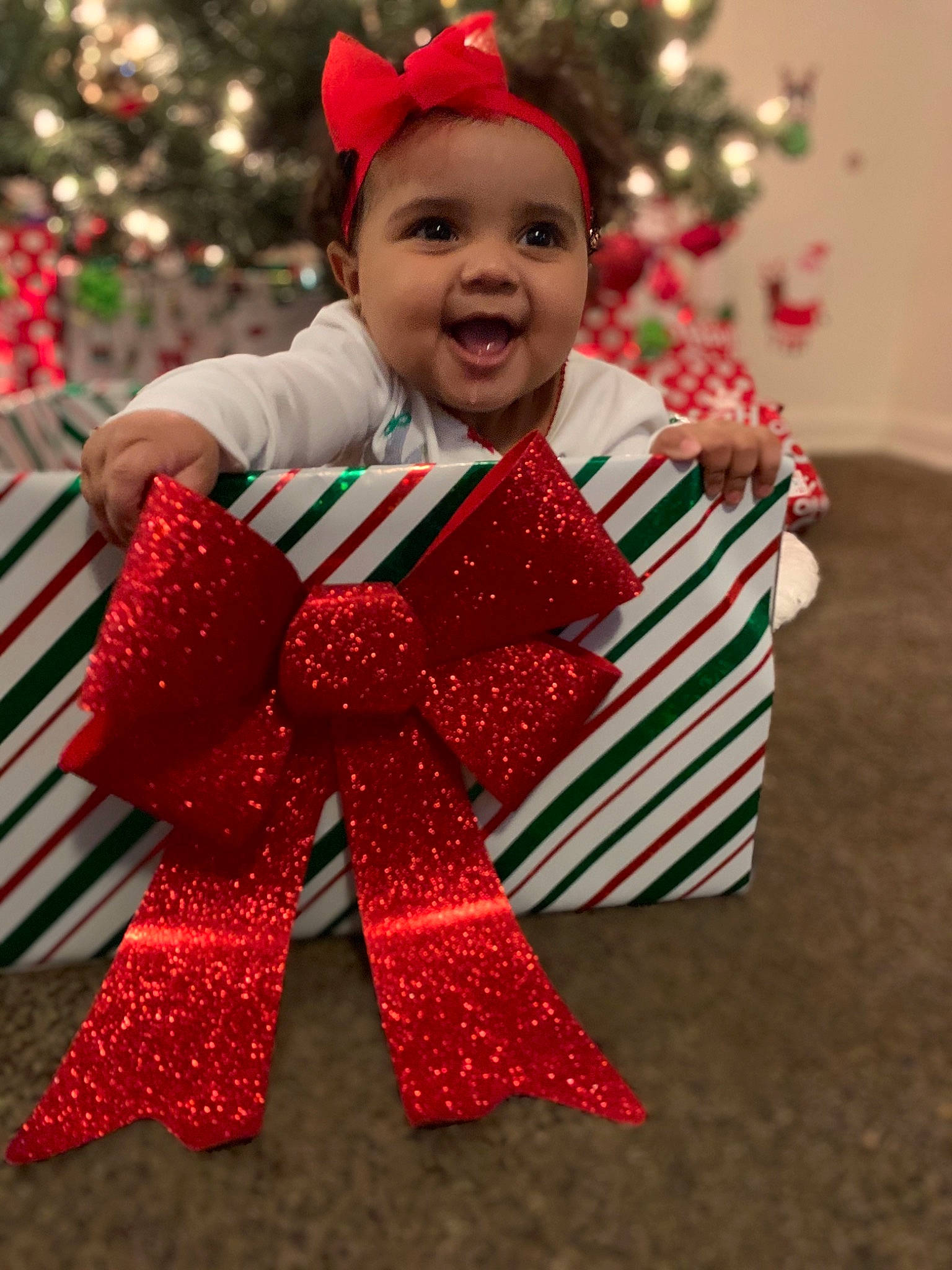 Maiya is registered to the contest to win money with this photo: child, christmas, christmas_decoration, christmas_eve, christmas_ornament, christmas_tree, costume, event, holiday, holiday_ornament, interior_design, person, red, smile, toddler, tradition