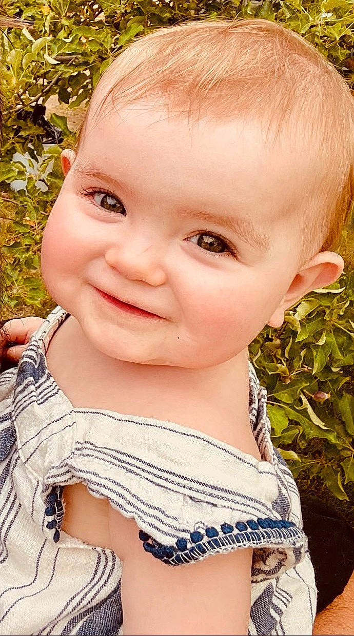 Autumn is registered to the contest to win money with this photo: baby_toddler_clothing, cheek, chin, ear, eye, eyebrow, eyelash, facial_expression, forehead, grass, happy, head, iris, joy, lip, nose, people_in_nature, person, plant, skin