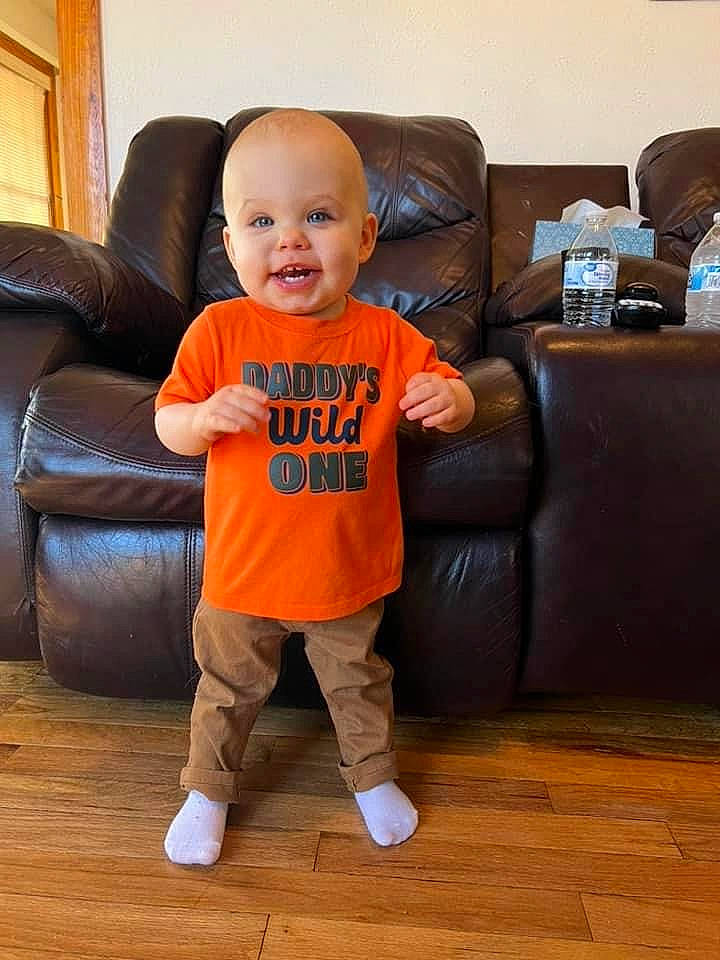 Russell joined the competition — help win amazing prizes! baby, baby_toddler_clothing, comfort, couch, floor, flooring, furniture, hardwood, laminate_flooring, leg, living_room, orange, person, picture_frame, sleeve, smile, sneakers, t_shirt, toddler, varnish