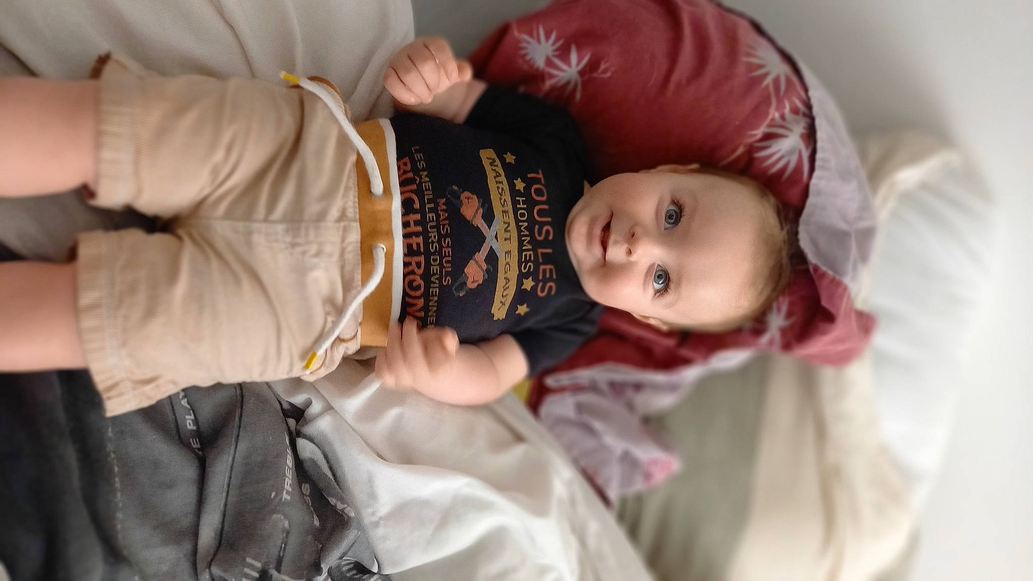 Nino participe au concours pour gagner de l'argent avec cette photo : arm, baby, child, comfort, couch, doll, dress, event, eyelash, hand, happy, hat, headgear, person, rose, sitting, sleeve, textile, toddler, tradition