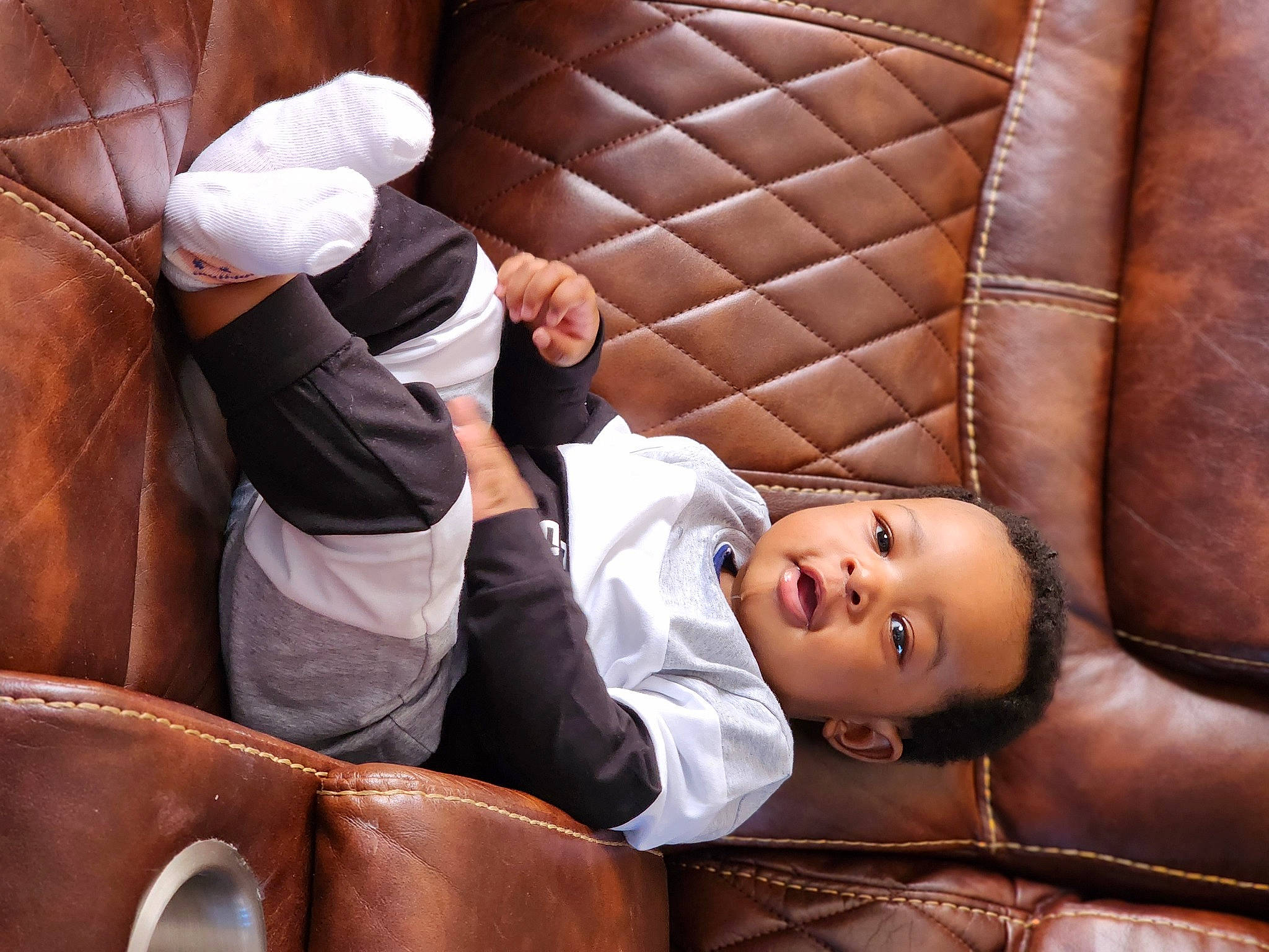 Tristan is registered to the contest to win money with this photo: baby, car_seat, chair, child, comfort, eyewear, flash_photography, flooring, fun, headgear, leather, leisure, luxury_vehicle, person, room, sitting, toddler, wood