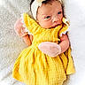 Rory joined the competition — help win amazing prizes! baby, bow, child, cute, eyes, face, headband, indoors, infant, laying_down, mittens, newborn, pink, portrait, skin, sleepwear, small_hands, soft_texture, white_blanket, yellow_dress