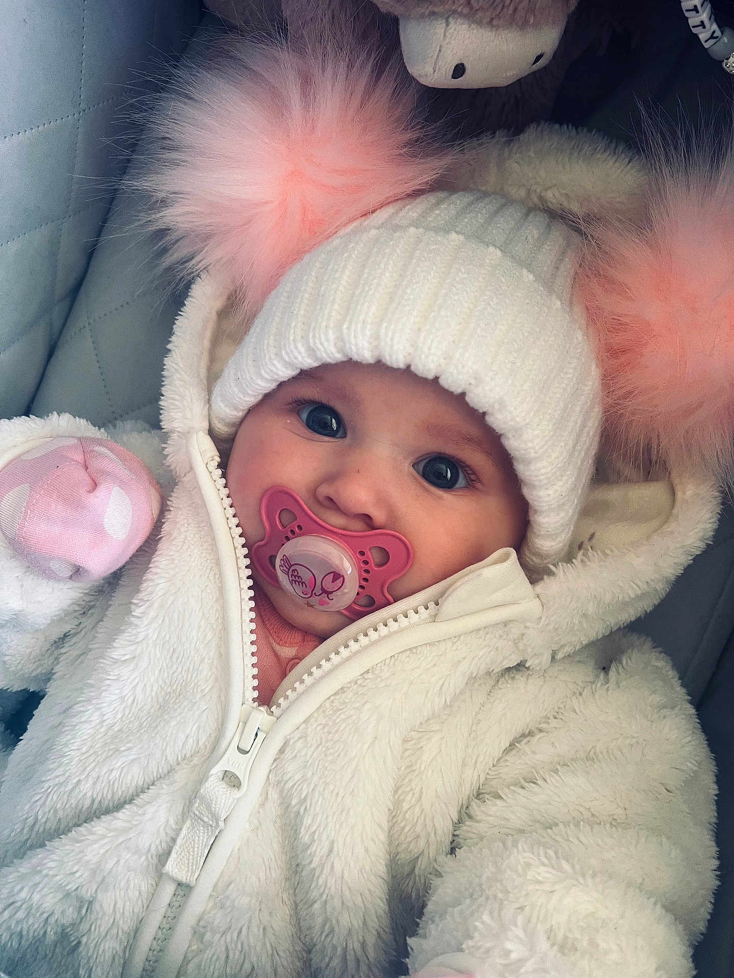 River joined the competition — help win amazing prizes! baby, child, pacifier, hat, pom_poms, white_jacket, knitted_hat, fluffy, cute, cold_weather, closeup, portrait, infant, warm_clothing, pink, blue_eyes, cozy, zipped_jacket, indoor, soft_texture