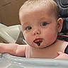 Brynlee is registered to the contest to win money with this photo: baby, child, face, high_chair, food, chocolate, messy, curious, skin, arm, mouth, indoor, person, closeup, infant, expression, seat, pink_bib, cute, young
