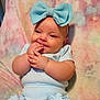 baby, child, blue_bow, headband, light_blue_clothing, pastel_blanket, cheeks, smile, fingers, sitting, cute, infant, indoors, soft_texture, happy, chubby, portrait, young_child, comfortable, cozy