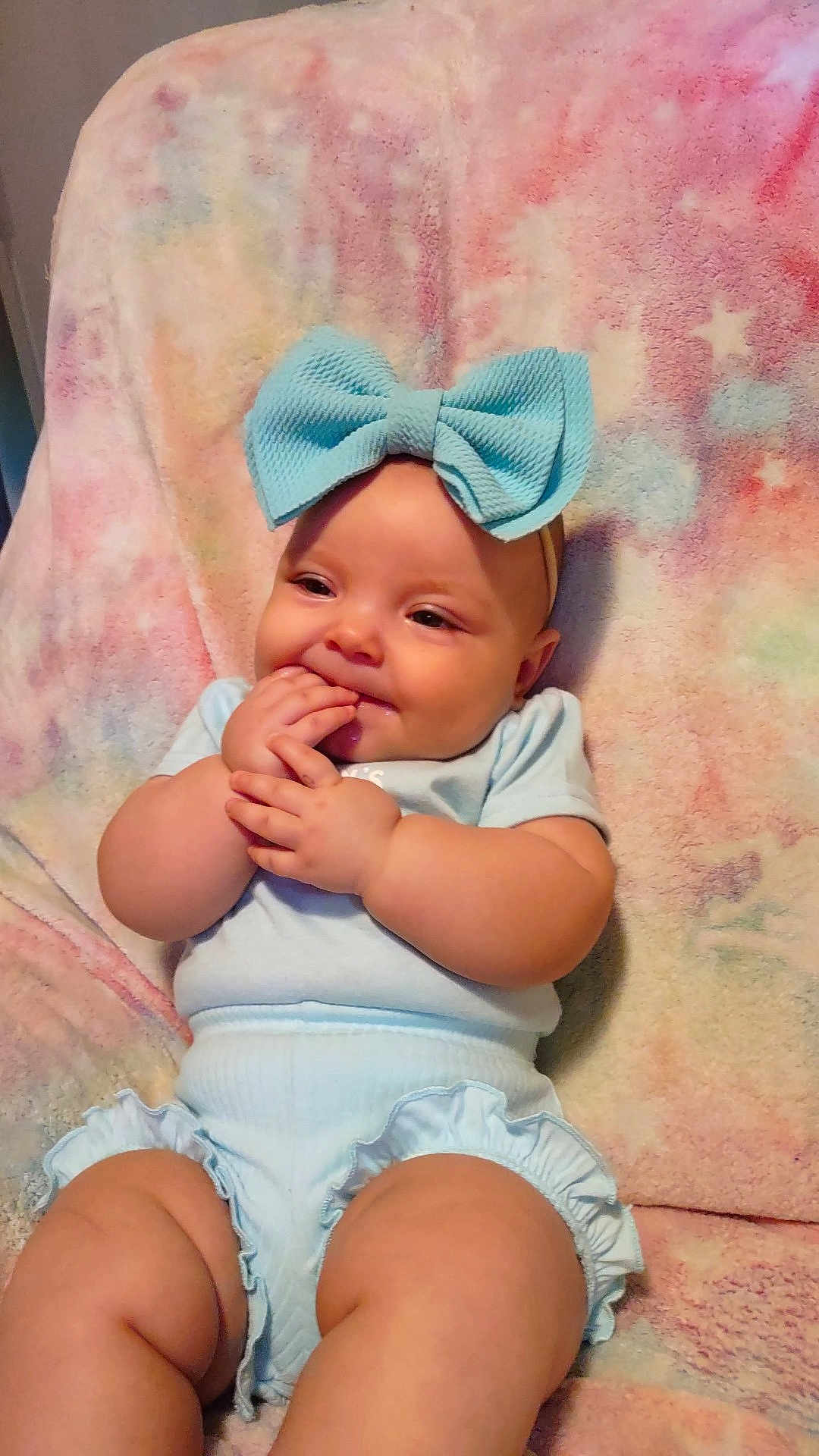 Irismae is registered to the contest to win money with this photo: baby, child, blue_bow, headband, light_blue_clothing, pastel_blanket, cheeks, smile, fingers, sitting, cute, infant, indoors, soft_texture, happy, chubby, portrait, young_child, comfortable, cozy