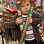 Bodhi joined the competition — help win amazing prizes! child, toddler, shopping_cart, wrapping_paper, holiday, christmas, store_aisle, gift_wrap, festive, clothing, striped_shirt, cardigan, shopping, retail, young_child, face, person, indoor, holiday_decor, curious