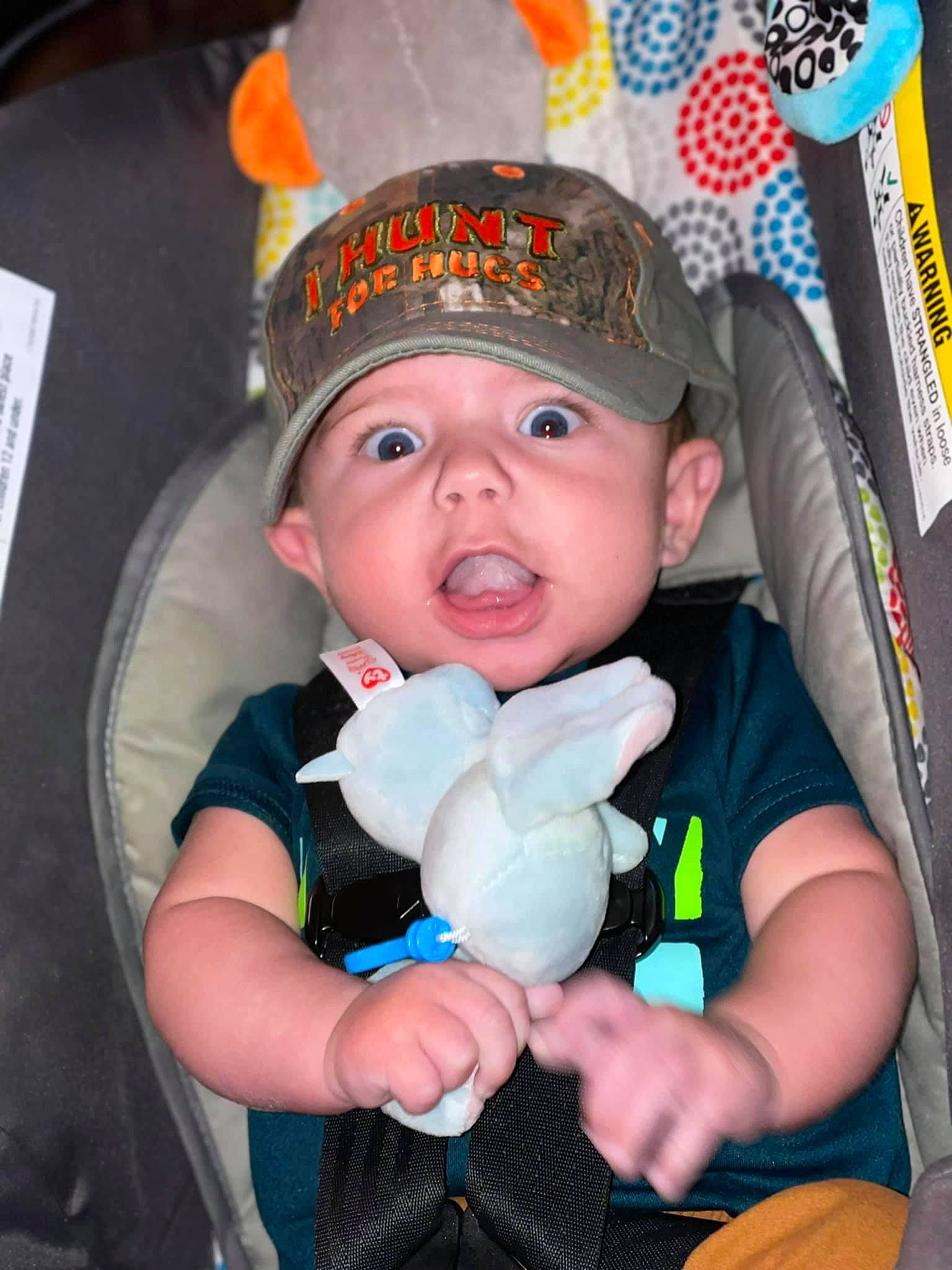 Branson is registered to the contest to win money with this photo: arm, baby, baby_products, baby_toddler_clothing, cap, cheek, child, costume_hat, fashion_accessory, fun, happy, hat, headwear, mouth, person, personal_protective_equipment, pink, sitting, skin, sun_hat