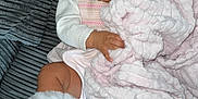 Nylah is registered to the contest to win money with this photo: baby, pacifier, pink_bow, blanket, white_boots, couch, gray_couch, child, infant, cute, wide_eyes, soft_blanket, textured_couch, clothing, portrait, indoors, comfortable, relaxed, hand, footwear
