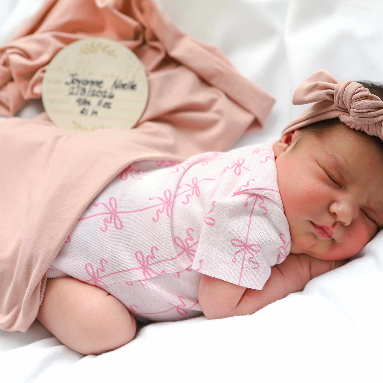 Joyanne Noelle joined the competition — help win amazing prizes! baby, blanket, child, clothing, cute, face, headband, indoors, infant, newborn, peaceful, pink, plush, portrait, rest, sleeping, soft, toddler, white, wrapped