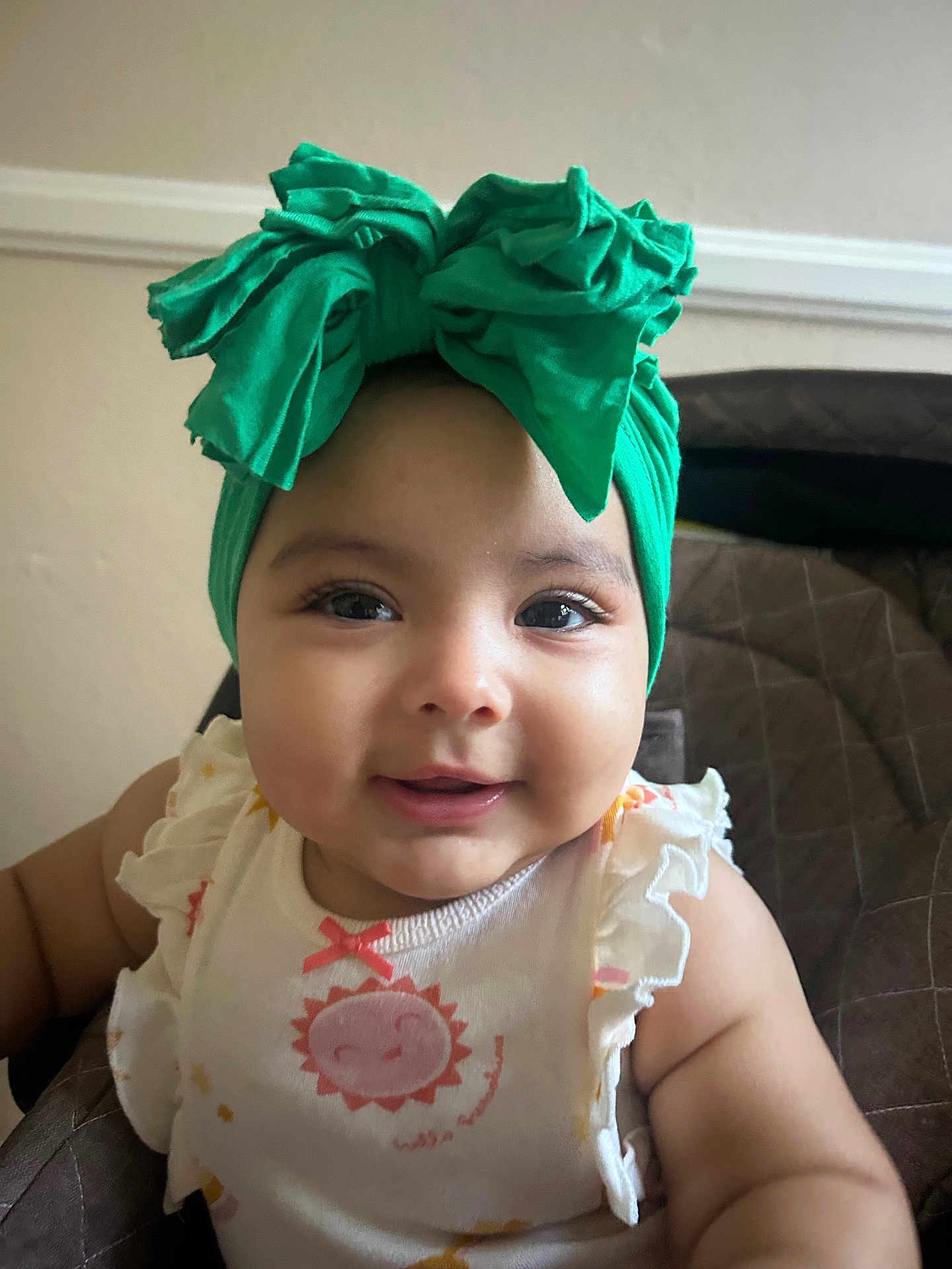 Aliany is registered to the contest to win money with this photo: baby, child, smiling, headband, green_bow, face, infant, cute, portrait, clothing, sitting, indoor, apparel, closeup, expression, happy, young_child, person, fashion, accessory