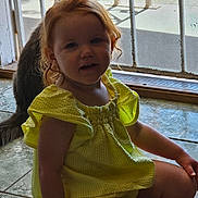 Cirilla is registered to the contest to win money with this photo: toddler, child, yellow_dress, cat, indoor, sitting, tile_floor, mesh_door, pet, curly_hair, smiling, young_child, casual, daylight, cute, domestic, home, portrait, playful, relaxed