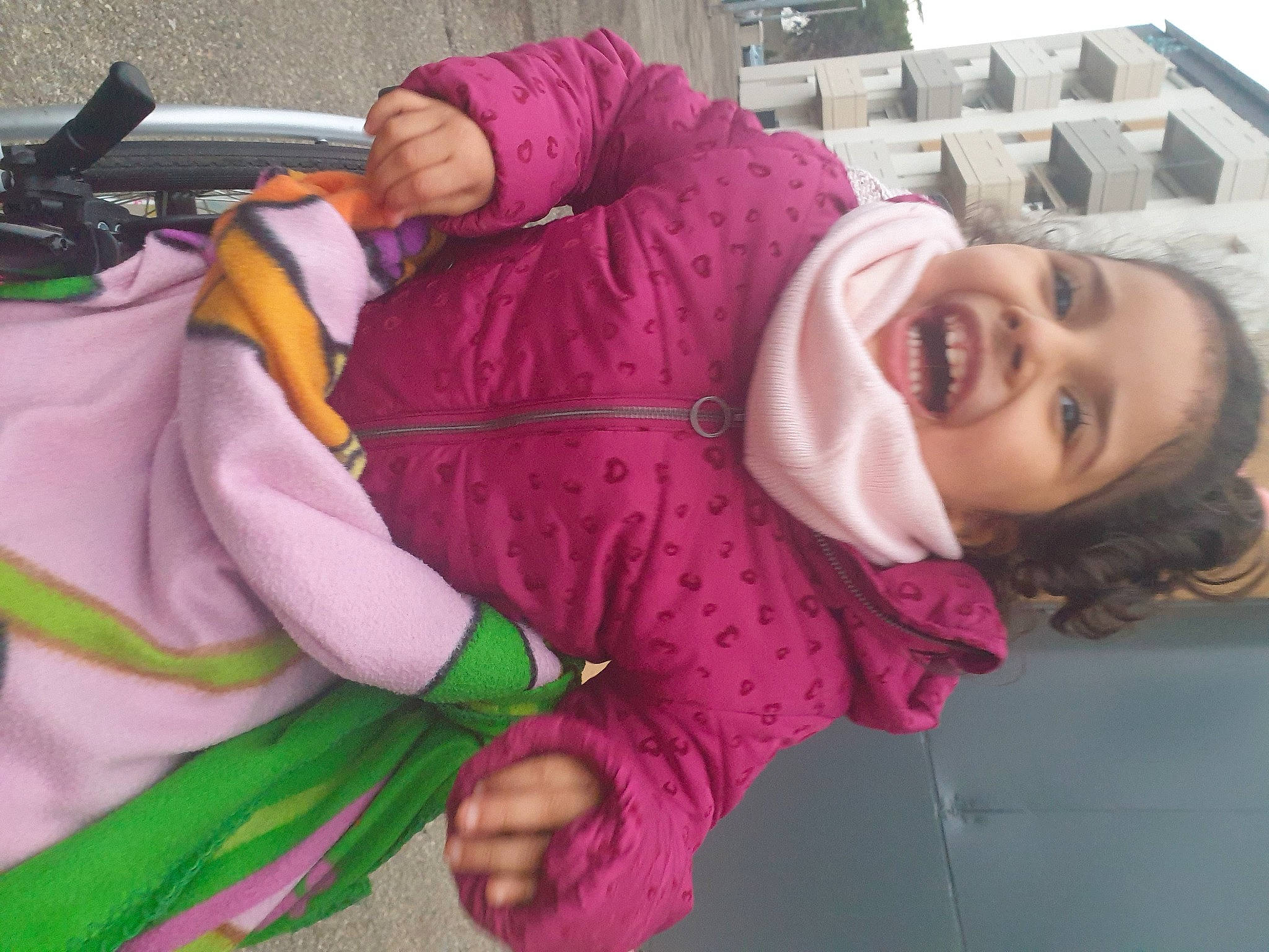 Mélina participe au concours pour gagner de l'argent avec cette photo : baby, baby_products, child, fun, happy, human_body, jacket, leisure, magenta, outerwear, person, pink, plant, purple, recreation, sitting, smile, sunglasses, toddler, tree