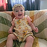 baby, smiling, sitting, indoor, headband, romper, blanket, couch, pattern, window, curtains, happy, child, person, clothing, infant, cute, portrait, home, cozy
