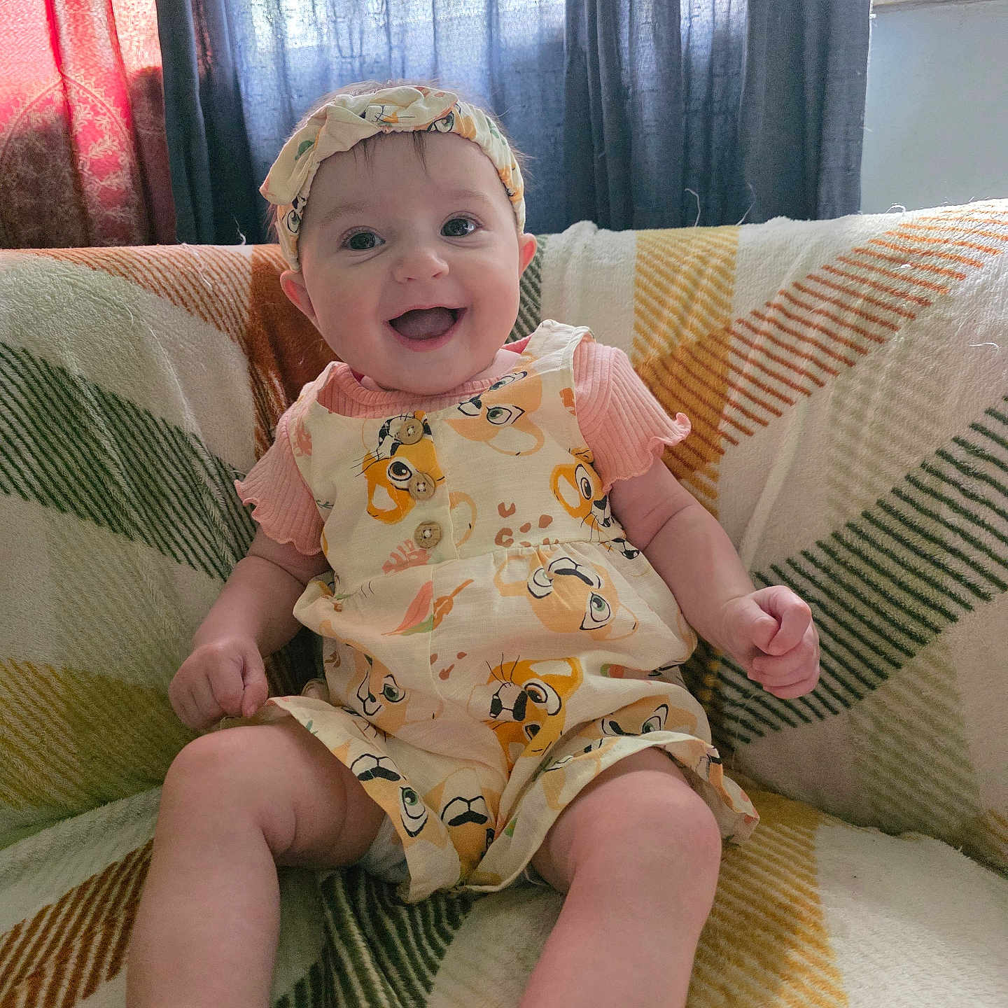Tracie joined the competition — help win amazing prizes! baby, smiling, sitting, indoor, headband, romper, blanket, couch, pattern, window, curtains, happy, child, person, clothing, infant, cute, portrait, home, cozy