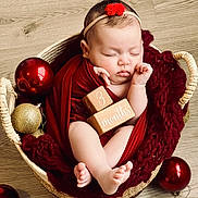 Baya participe au concours pour gagner de l'argent avec cette photo : baby, sleeping, basket, red_blanket, wooden_blocks, ornaments, red_ornaments, gold_ornaments, headband, flower_headband, infant, feet, hands, cute, cozy, holiday_theme, floor, wrapped, peaceful, portrait