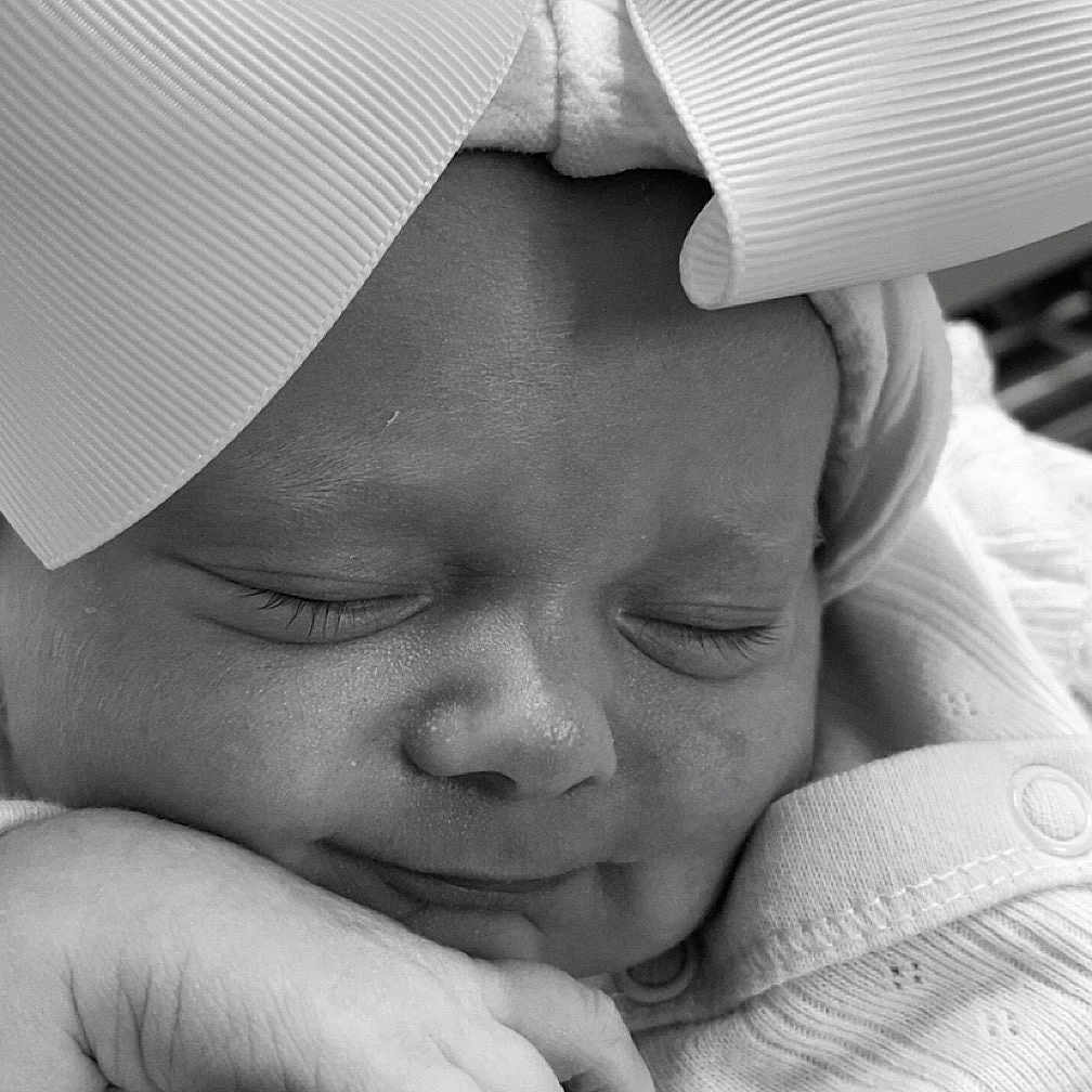 Arabella-Rae is registered to the contest to win money with this photo: adorable, baby, black_and_white, bow, child, closeup, clothing, cozy, cute, face, hand, headwear, infant, newborn, peaceful, portrait, resting, sleeping, soft, toddler