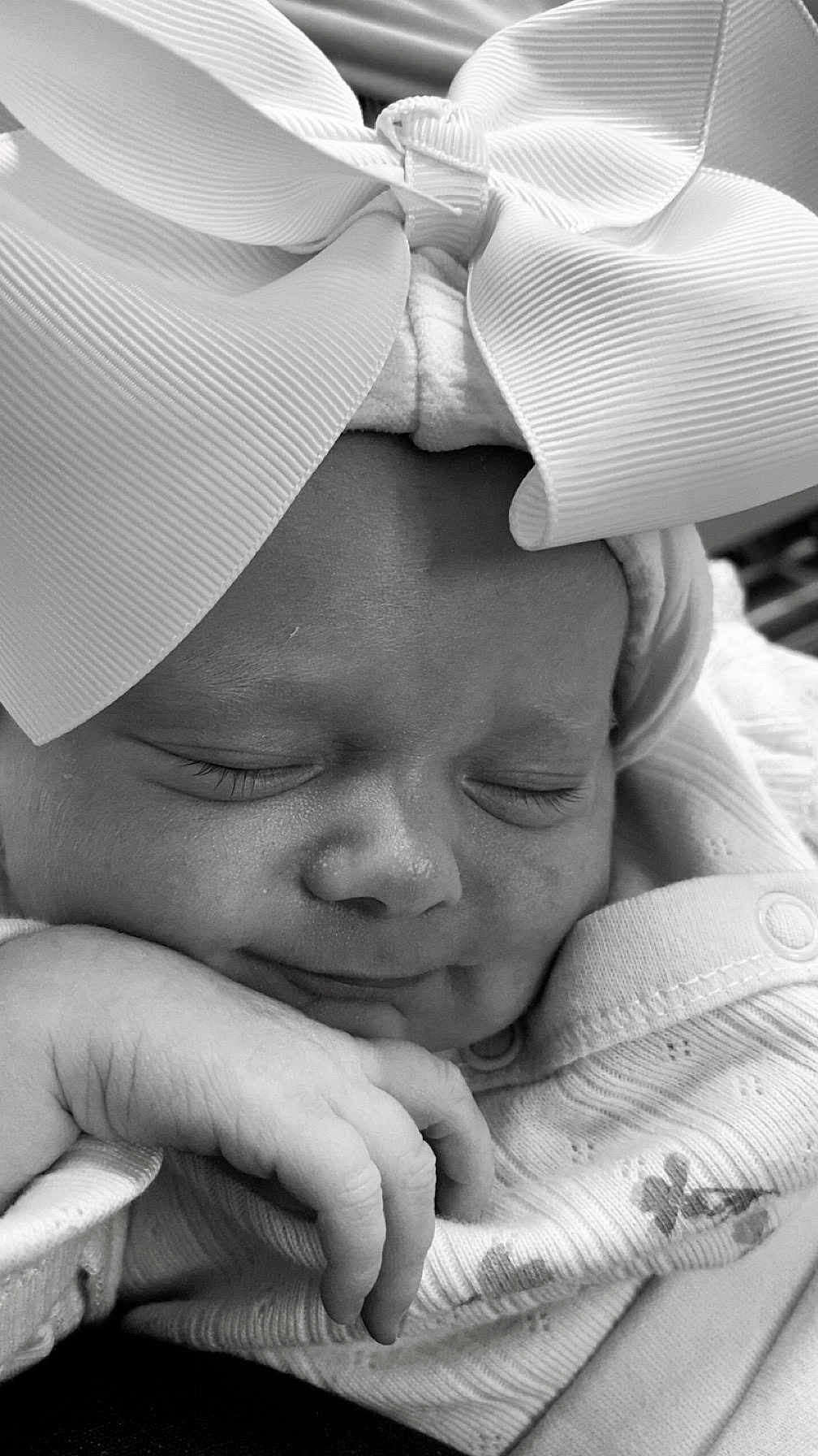 Arabella-Rae is registered to the contest to win money with this photo: adorable, baby, black_and_white, bow, child, closeup, clothing, cozy, cute, face, hand, headwear, infant, newborn, peaceful, portrait, resting, sleeping, soft, toddler