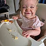 baby, child, crumbs, cute, expression, face, feeding, food, funny, happy, high_chair, indoor, infant, messy, person, pink_clothing, seat, smiling, table, toy