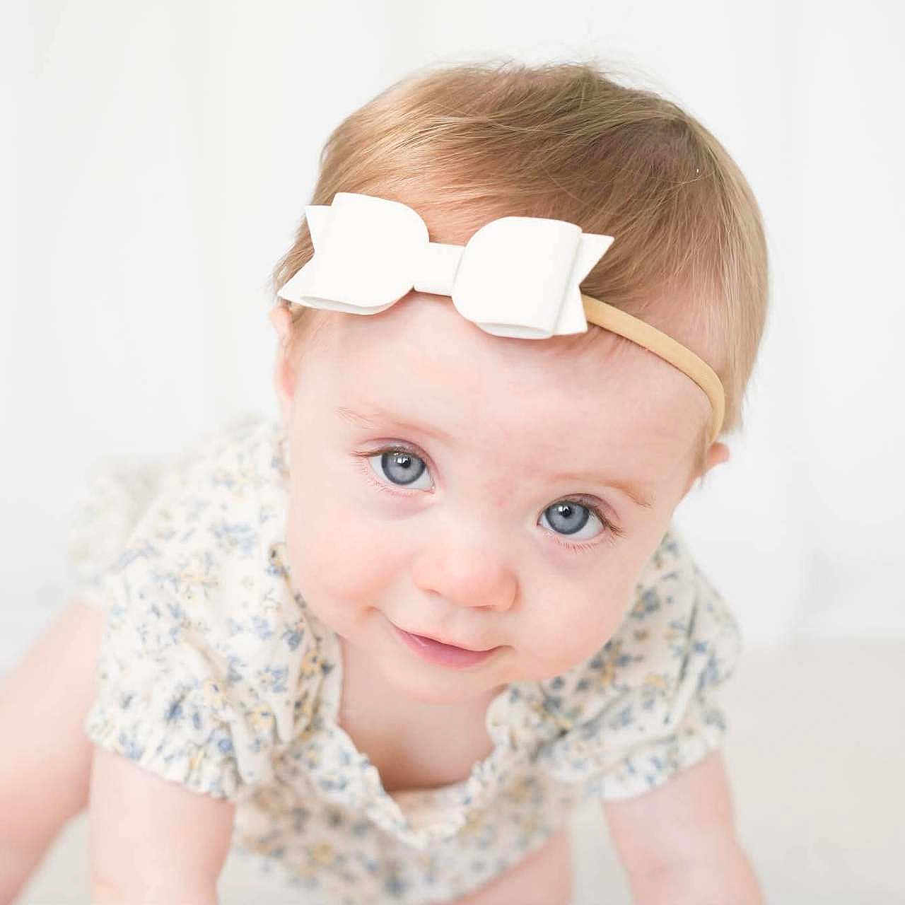 Abbigale joined the competition — help win amazing prizes! baby, baby_girl, blue_eyes, bow, child, closeup, crawling, cute, expression, fair_skin, floral_clothing, head, headband, indoor, infant, person, portrait, smiling, soft_lighting, young_child