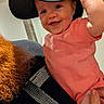 Abbigale joined the competition — help win amazing prizes! apparel, baby, cap, child, closeup, clothing, curly_hair, cute, face, hand, happy, hat, holding, indoor, infant, person, pink_shirt, portrait, red_hair, smile