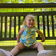 Audrey joined the competition — help win amazing prizes! toddler, child, smiling, outdoor, bench, wooden_bench, sunlight, greenery, summer_clothing, shoes, happy, face, person, nature, daylight, playful, casual, young_child, blue_dress, yellow_pattern