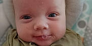 Gabriel participe au concours pour gagner de l'argent avec cette photo : baby, child, closeup, clothing, cushion, cute, expression, eyes, face, green_shirt, head, human, indoors, infant, person, portrait, sitting, skin, smile, young