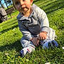 toddler, child, grass, daisies, park, trees, sunlight, outdoor, person, clothing, socks, bench, bicycle, cyclist, nature, daylight, greenery, casual, portrait, cute