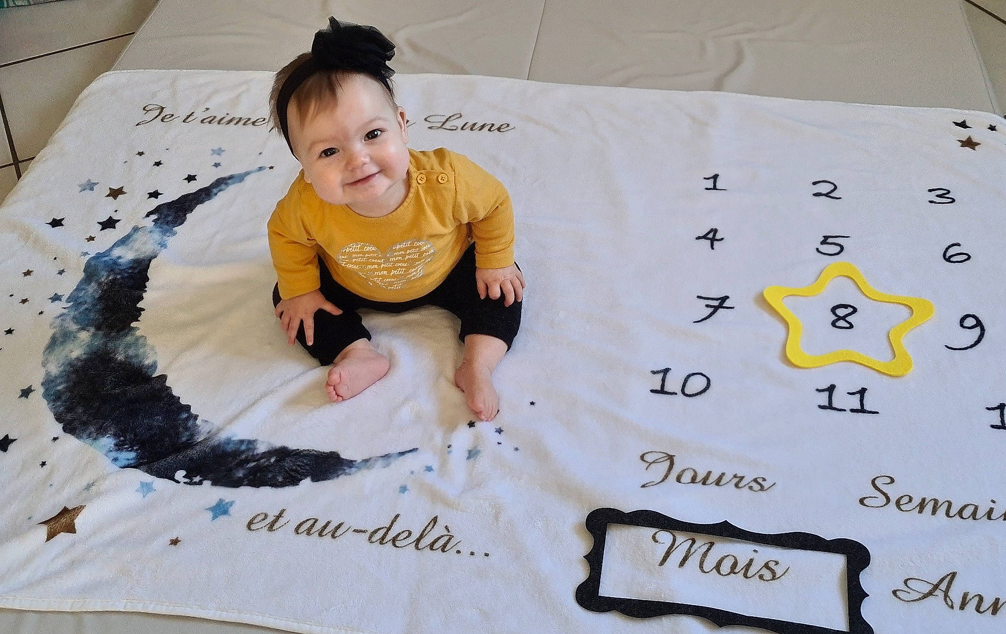 Alessia a rejoint le concours — aidez-le/la à gagner de superbes lots ! bed, bedding, carpet, child, comfort, flooring, font, fun, happy, joy, leisure, linens, pattern, person, product, shirt, sitting, sleeve, smile, t_shirt