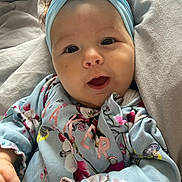 Romi-Dalton is registered to the contest to win money with this photo: baby, blanket, blue, child, clothing, cozy, cushion, cute, face, floral_clothing, hands, happy, headband, indoors, infant, person, portrait, skin, smiling, young