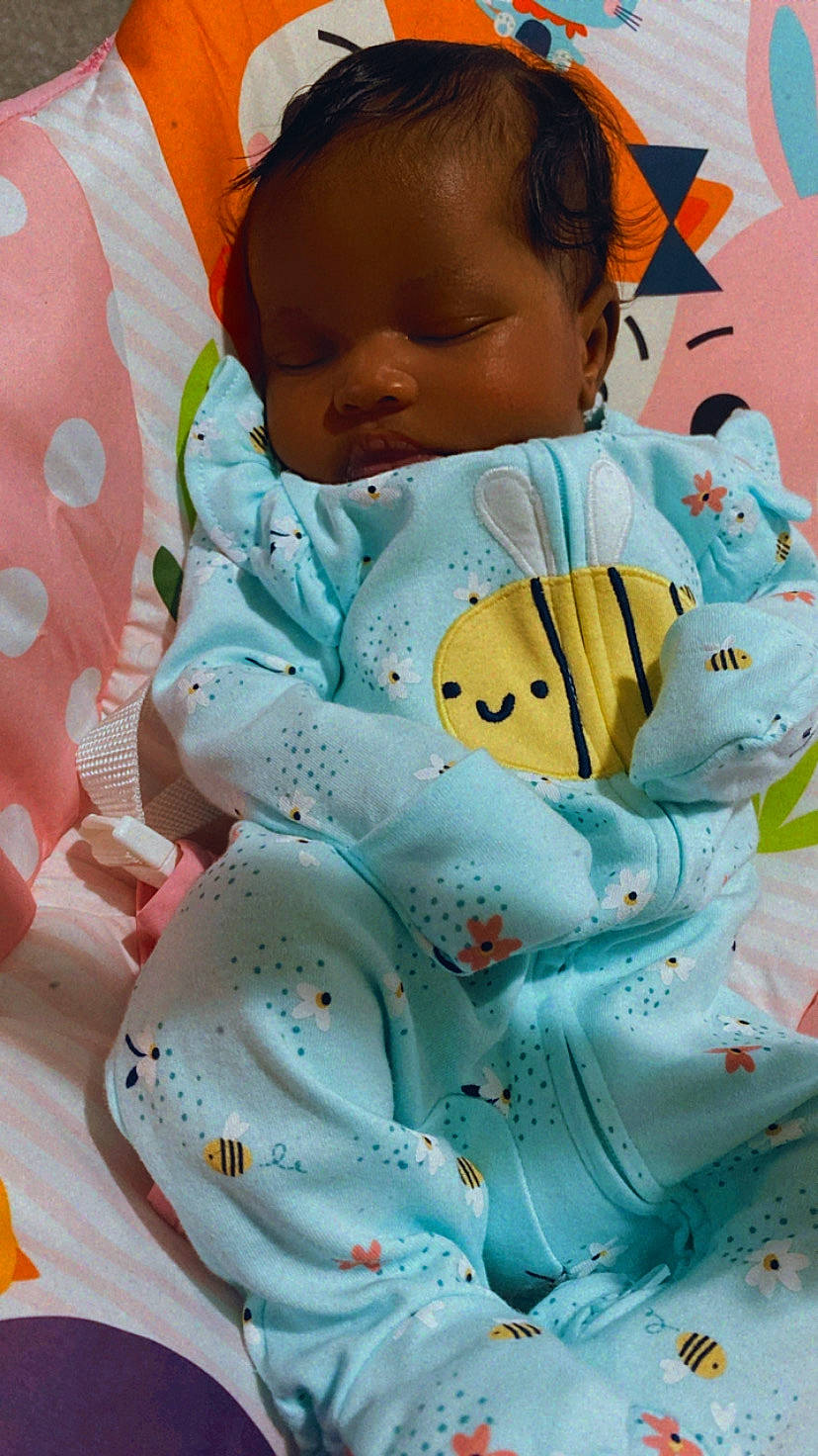 Khloé Chanel is registered to the contest to win money with this photo: baby, baby_products, baby_sleeping, baby_toddler_clothing, cheek, child, comfort, eye, face, green, happy, head, linens, pattern, person, pink, skin, sleeve, textile, toddler