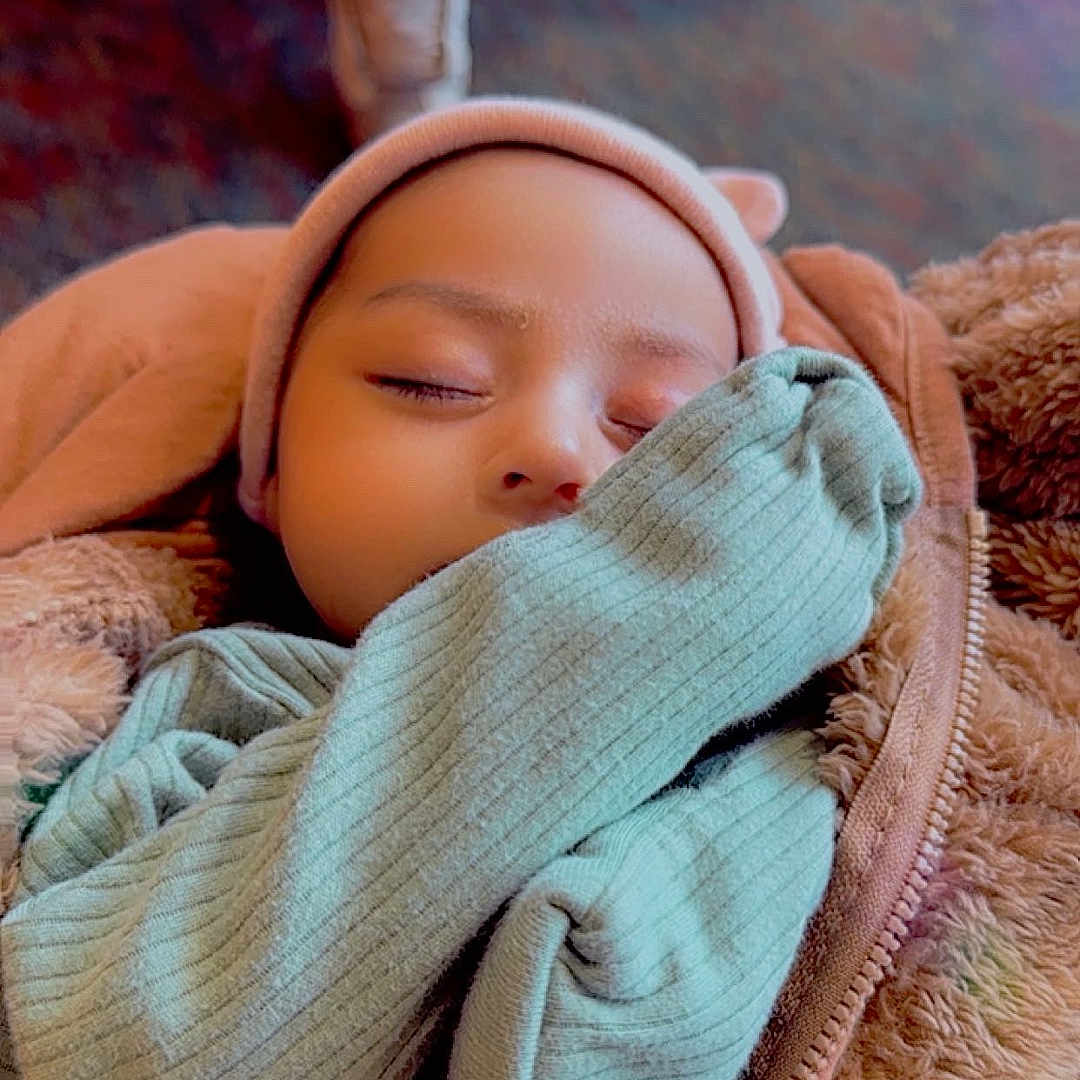 Dunya joined the competition — help win amazing prizes! baby, blanket, bonnet, cap, clothing, coat, face, glove, happy, hat, head, hood, jacket, newborn, person, photography, portrait, sleeping, smile, yawning