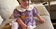 Camila joined the competition — help win amazing prizes! baby, child, toddler, portrait, sitting, couch, bow, headband, yellow, dress, striped_clothing, white_tights, smiling, face, indoors, living_room, furniture, pillows, blanket, coffee_table