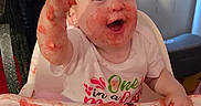 Camila joined the competition — help win amazing prizes! baby, birthday, birthday_hat, cake, cake_smash, celebration, child, curtain, food, frosting, happy, high_chair, indoor, messy, party, pink_clothing, portrait, smiling, watermelon_cake, window