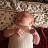 baby, blanket, child, clothing, curious, cute, fabric, head, indoor, infant, lying_down, pattern, person, portrait, resting, skin, sleepwear, small_hands, soft_lighting, warm