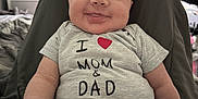 Lakiyah is registered to the contest to win money with this photo: baby, child, smiling, curly_hair, tshirt, beaded_pacifier_clip, indoor, bedroom, furniture, drawer, curtain, window, person, cute, happy, infant, clothing, face, seated, home