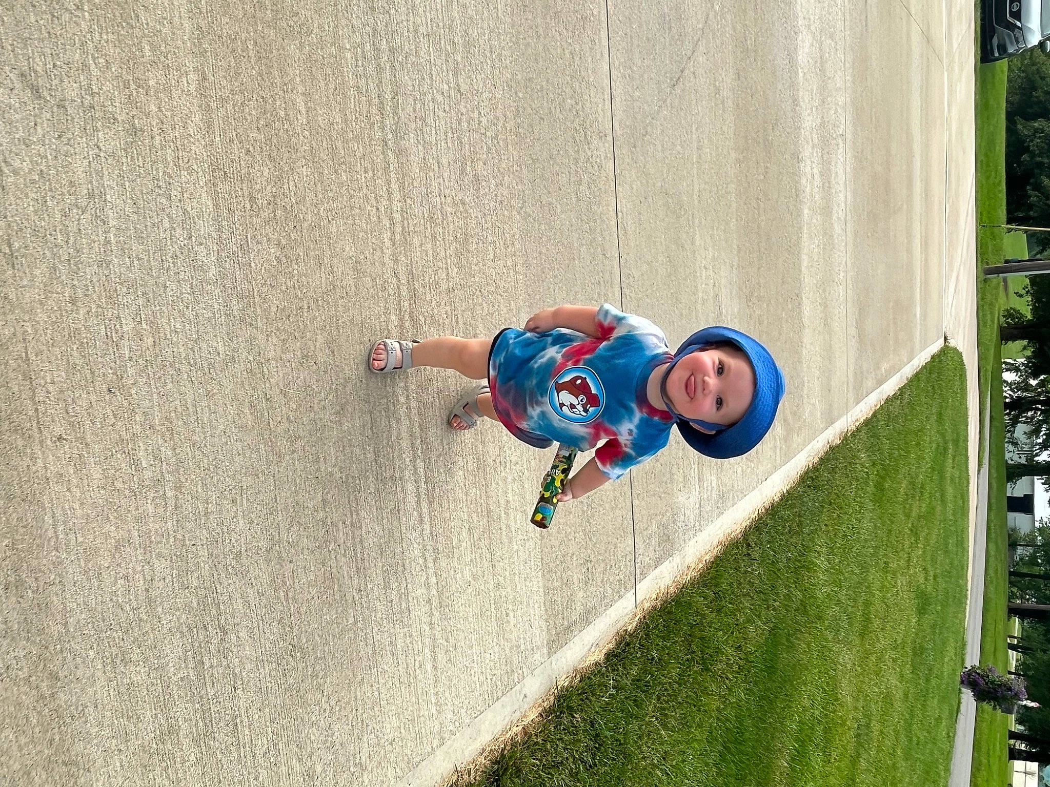 Helena is registered to the contest to win money with this photo: adventure, asphalt, child, concrete, electric_blue, extreme_sport, fun, grass, headwear, joy, landscape, leisure, person, plant, recreation, sidewalk, slope, sports, toddler, tree