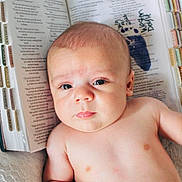 Weston Huffman joined the competition — help win amazing prizes! baby, infant, shirtless, face, eyes, expression, bible, book, pages, text, lace, background, skin, human, newborn, lying_down, indoors, closeup, portrait, serious