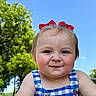 toddler, child, smile, blue_sky, red_bow, checkered_dress, outdoor, green_trees, sunny_day, rosy_cheeks, happy, portrait, grass, summer, cute, person, nature, head, face, baby