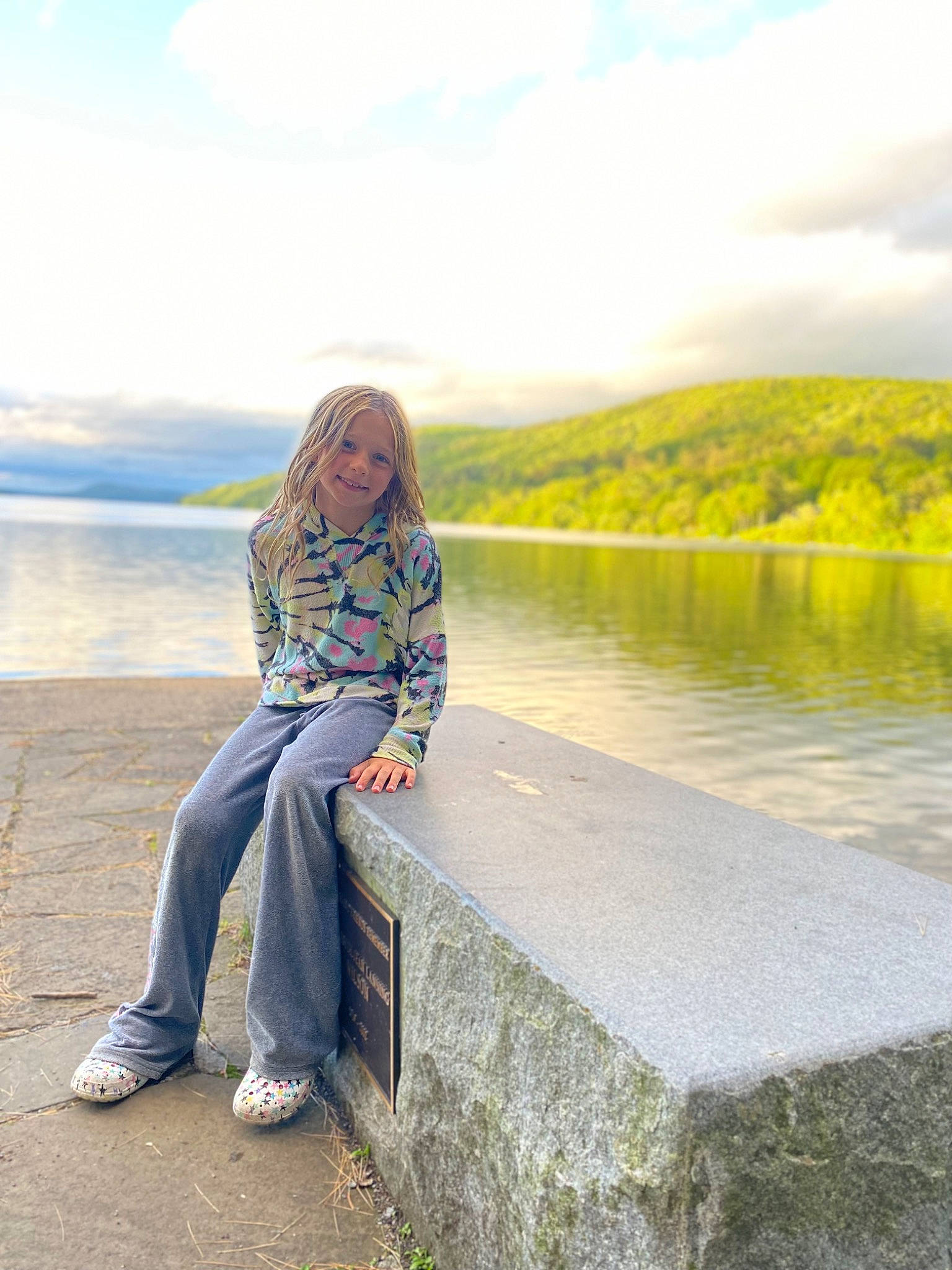 Amelia is registered to the contest to win money with this photo: bank, calm, cloud, flash_photography, grass, happy, horizon, joy, lake, landscape, leisure, people_in_nature, person, plant, reservoir, shore, sky, sunlight, travel, tree